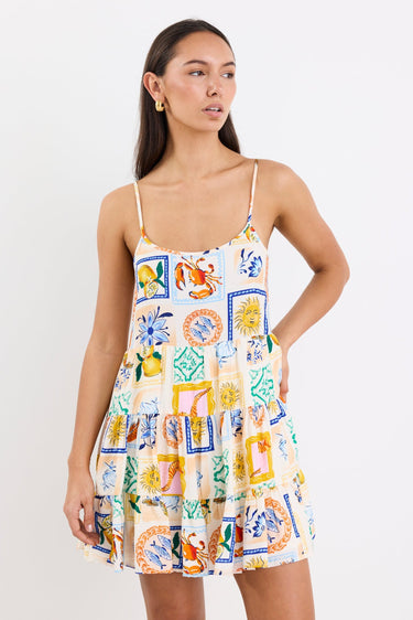 model wears a mini dress featuring a vibrant holiday print