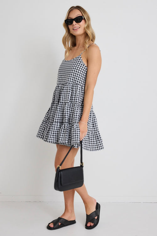 model wears a black and white gingham mini dress