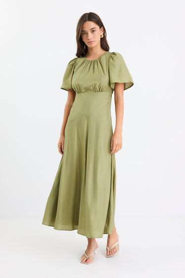 Woman wearing a long green dress with gathering and puff sleeves