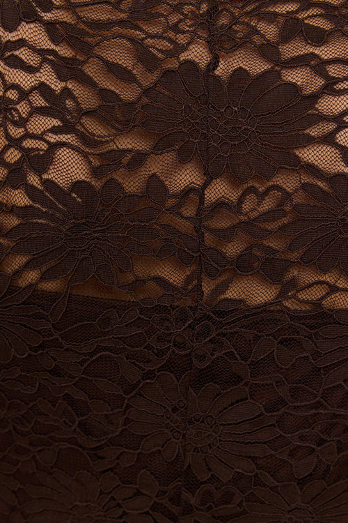 Close-up of a dark brown lace garment with a floral pattern and sheer mesh overlay.
