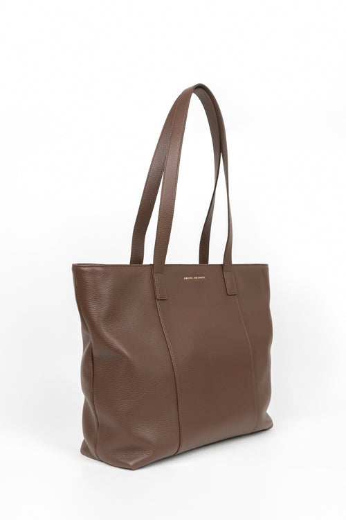 A brown pebbled leather tote bag with dual shoulder straps, shown from a three-quarter angle against a clean white background.