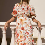 model wears a orange floral midi dress