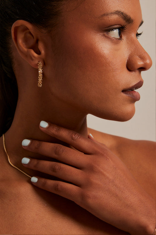 Model wears a gold hoop earring