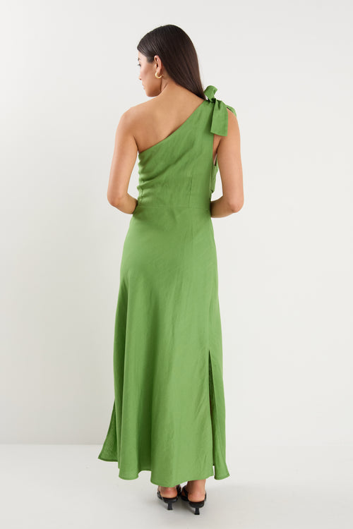 Model wears a one shoulder green midi dress with white heels