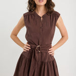 Woman wearing a brown dress with a belt on a white background