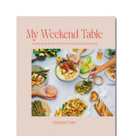Book cover of 'My Weekend Table' with images of food and people eating.