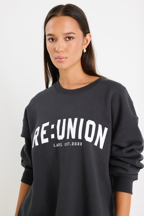 Woman wearing a charcoal grey oversized sweatshirt with 