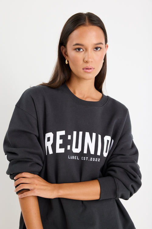 Woman wearing a charcoal grey oversized sweatshirt with 