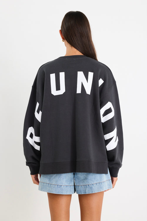 Woman wearing a charcoal grey oversized sweatshirt with 