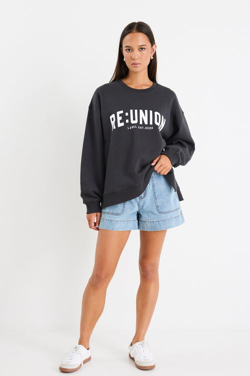 Woman wearing a charcoal grey oversized sweatshirt with 