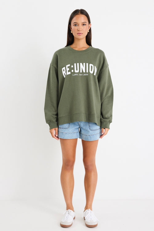 Woman wearing a khaki green oversized sweatshirt with 