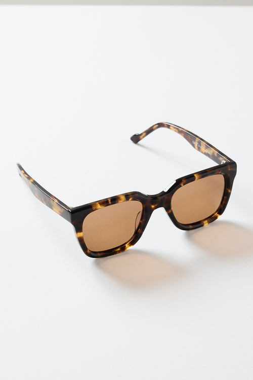 Rounded-square tortoiseshell sunglasses with warm brown tinted lenses, photographed on a white background