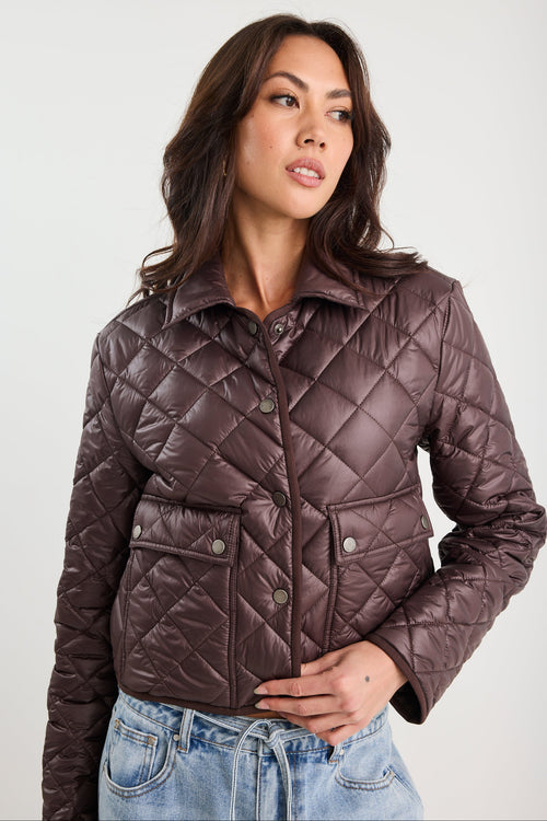 Woman wearing a quilted jacket on a white background