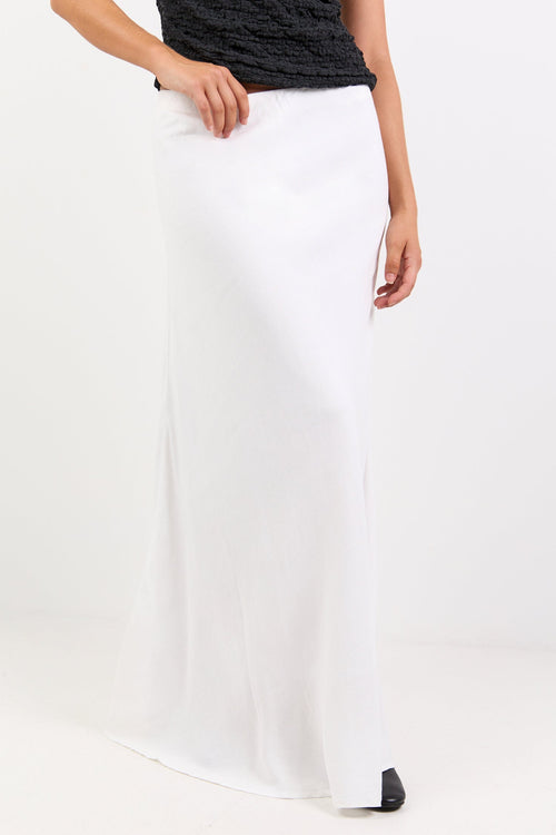 Person wearing a black top and white skirt on a white background