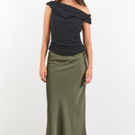 Woman wearing a black off-shoulder top and green skirt on a white background