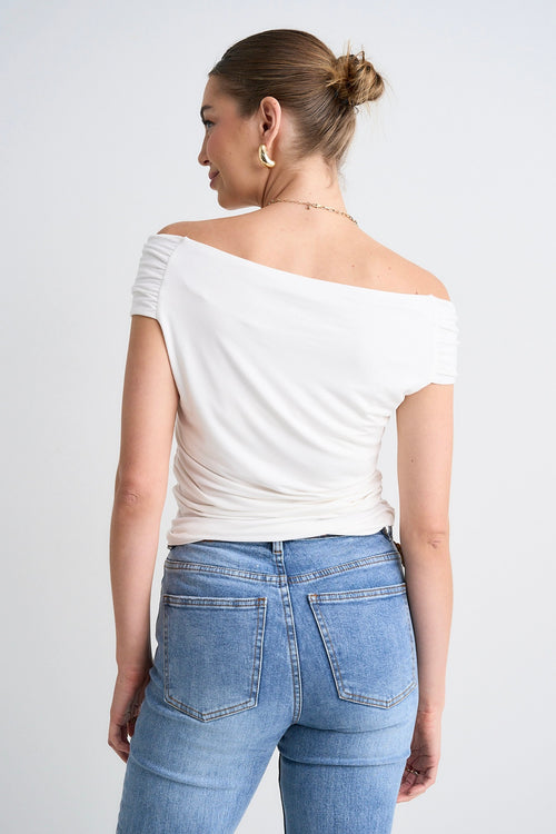 model wears a white off the shoulder top