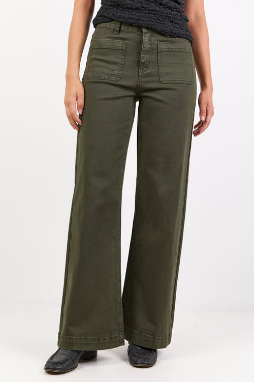 Person wearing olive green pants and a dark top on a white background