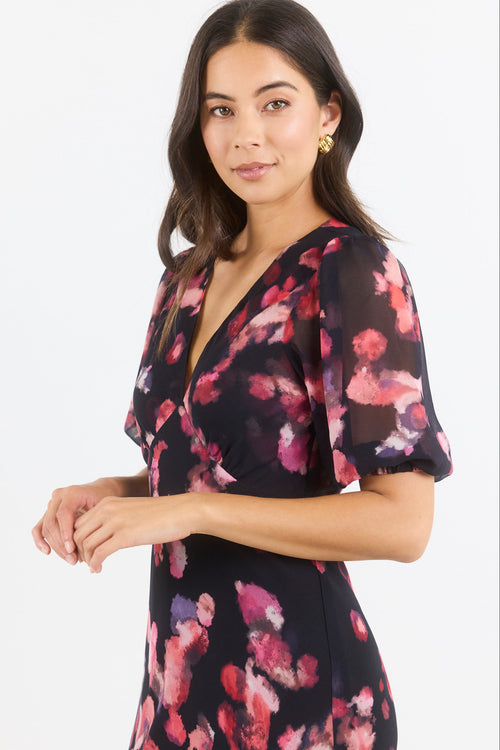 Woman wearing a black floral dress on a white background