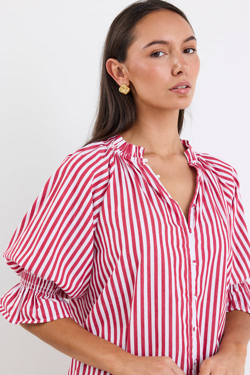 Woman wearing a red and white striped top and blue jeans