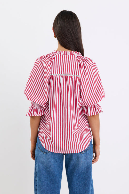 Woman wearing a red and white striped top and blue jeans