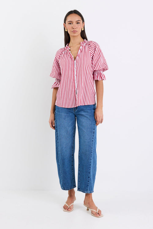 Woman wearing a red and white striped top and blue jeans