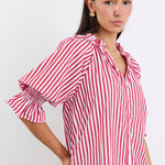 Woman wearing a red and white striped top and blue jeans