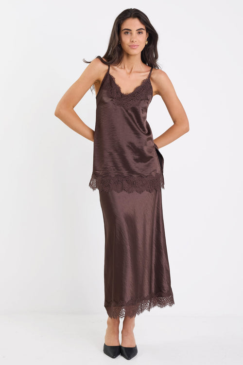Woman wearing a brown satin nightgown on a white background