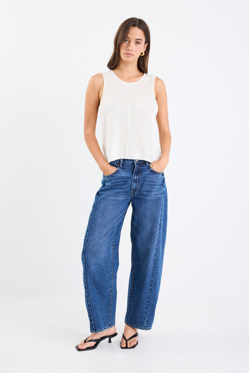 Model wearing a light white knit and blue jeans