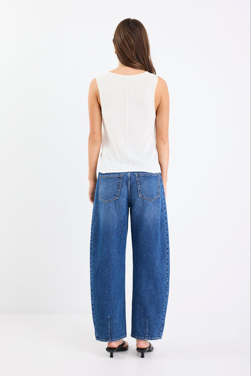 Model wearing a light white knit and blue jeans