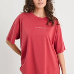 Woman wearing a red t-shirt with text on a plain background