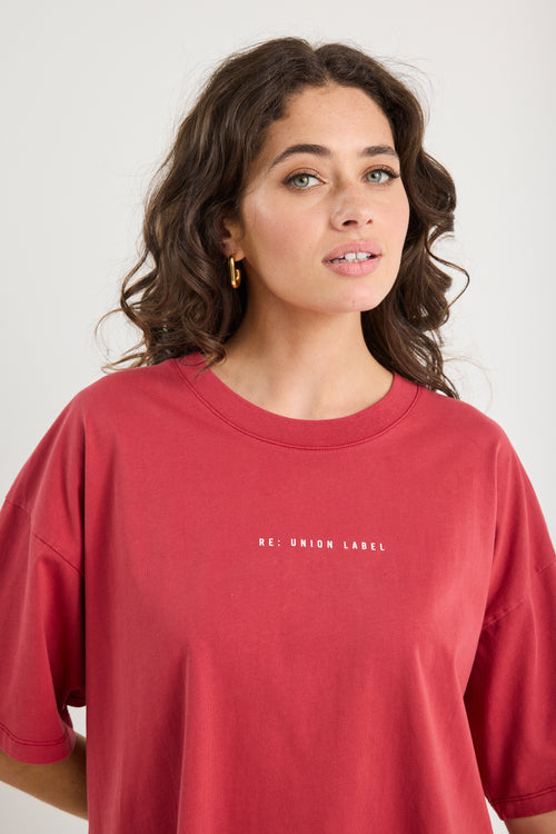 Woman wearing a red t-shirt with 'RE: UNION LABEL' text on a white background