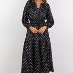 Woman wearing a black dress with white patterns on a white background