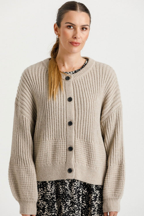 model wears a beige cardigan