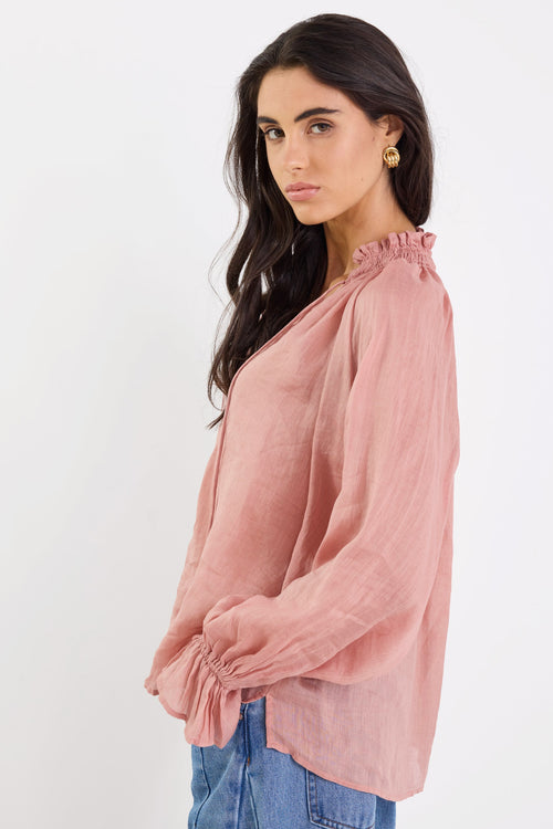 Woman wearing a pink blouse with a white background