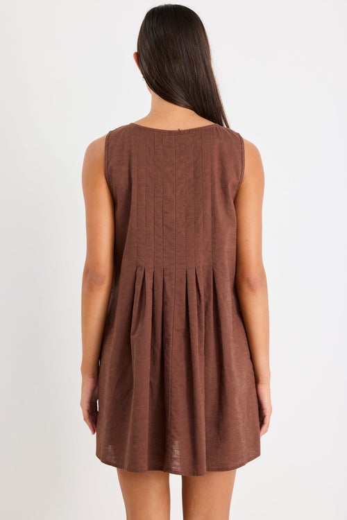 Woman wearing a brown mini dress with tie front and pleating