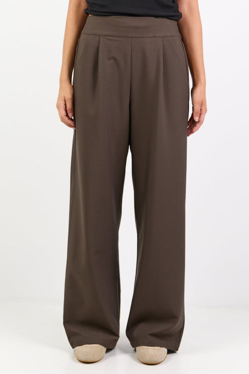 Brown wide-leg pants worn by a person on a white background