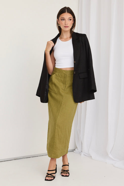 model wears a green skirt and white shirt