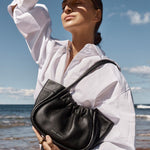 model wears a black shoulder bag