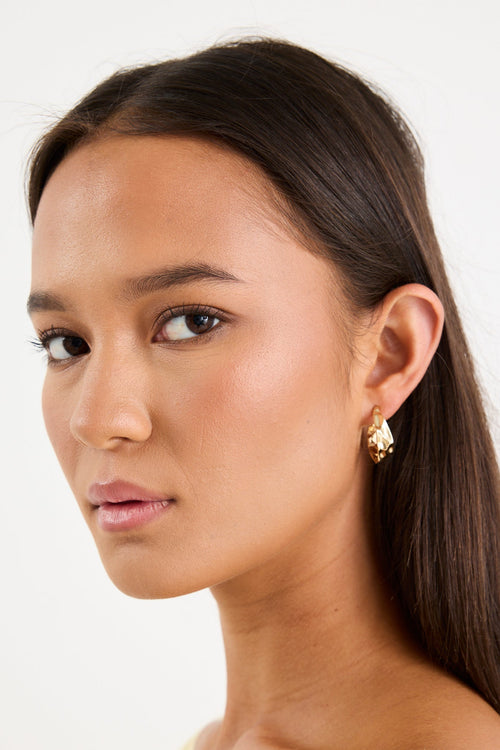 Woman wearing a gold chunky earring
