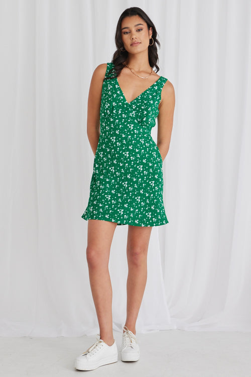 model wears a green floral mini dress