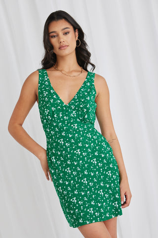 model wears a green floral mini dress
