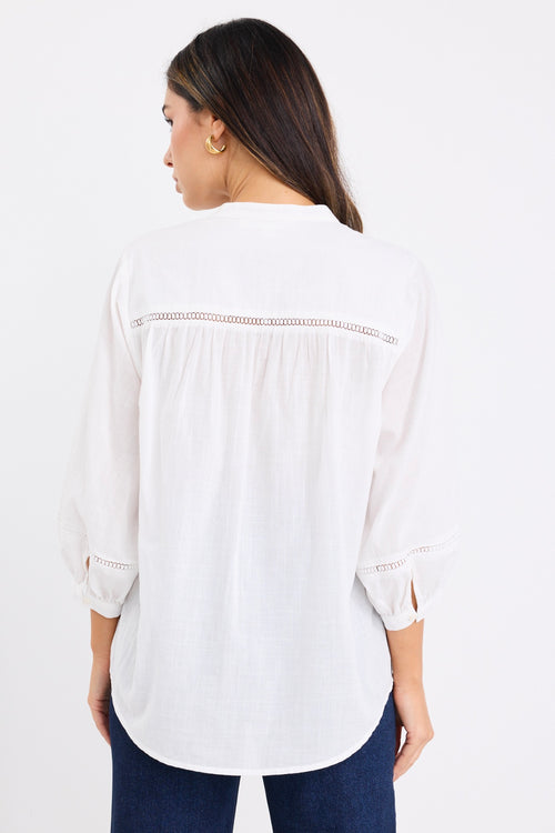 women wears a white blouse with dark blue jeans