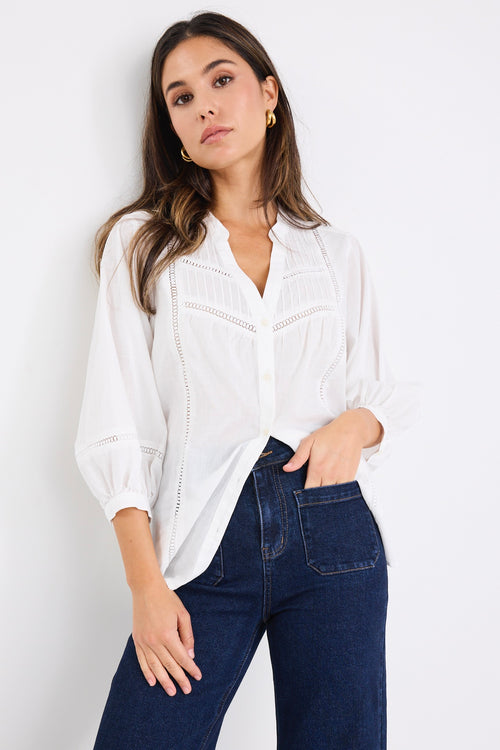 women wears a white blouse with dark blue jeans