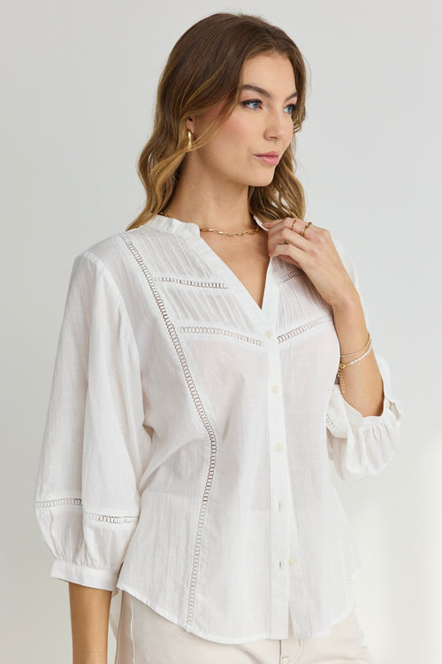 model wears a white button up blouse