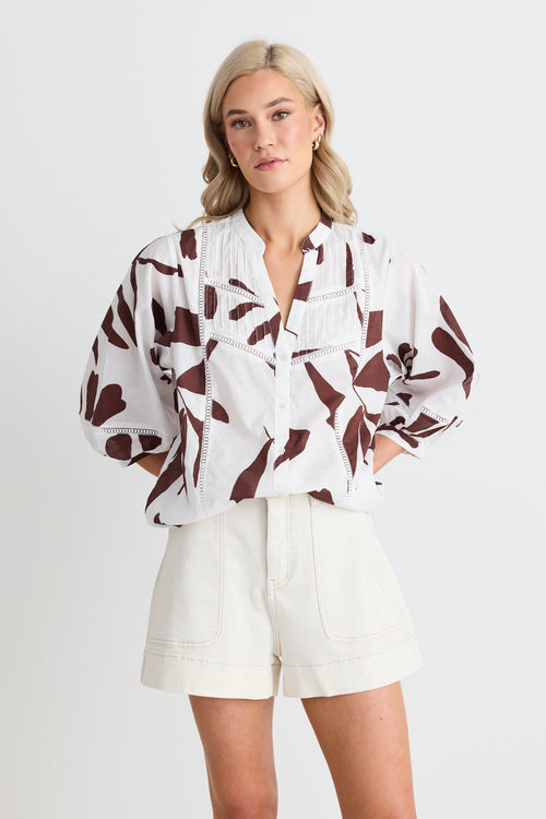 model wears white a brown patterned button down shirt