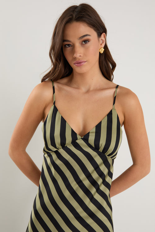 model wears a black and khaki stripe maxi dress with black heels 