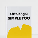 A hardcover book titled 'Ottolenghi SIMPLE TOO' with a white cover, bold black text, and a large yellow abstract shape at the bottom, photographed against a clean white background.