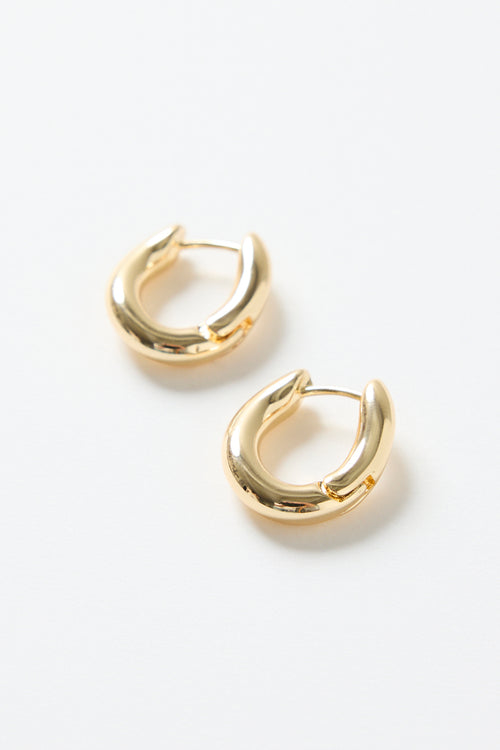 A pair of small oval-shaped wavy gold hoop earrings photographed on a clean white background.