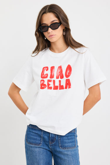 The model wears a white t-shirt with red graphic text and blue jeans