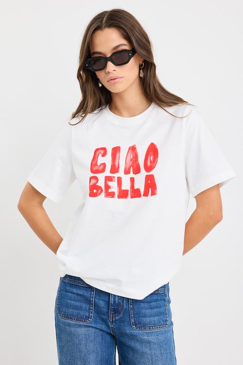 The model wears a white t-shirt with red graphic text and blue jeans